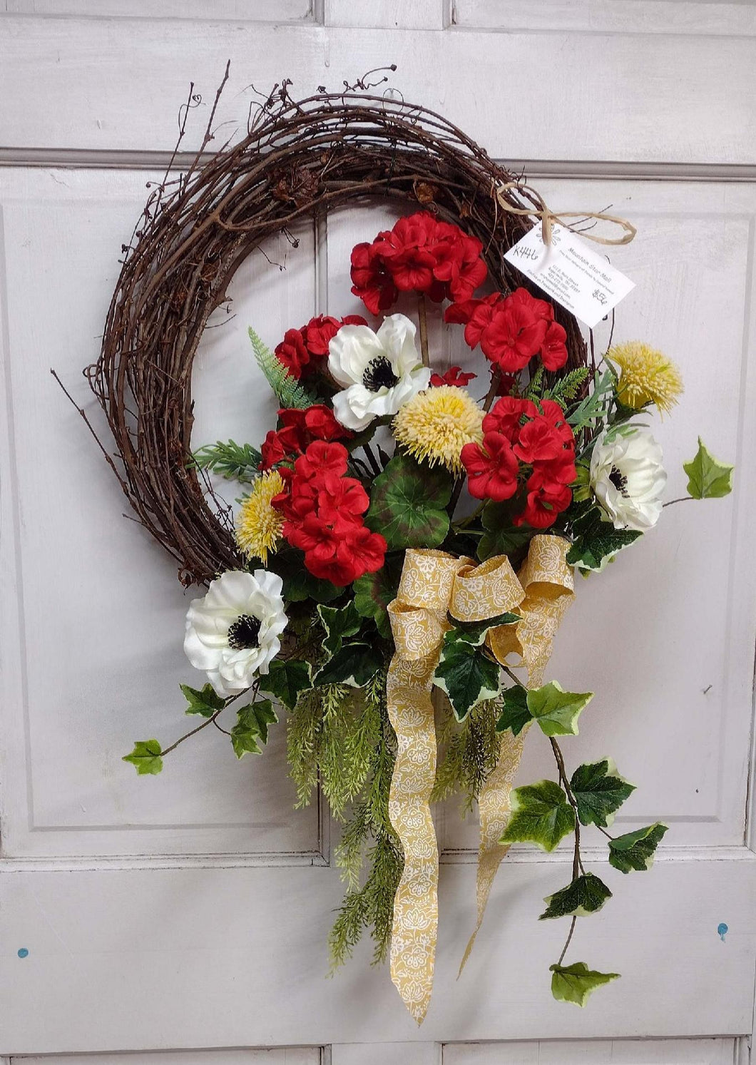 K446 - Wreath with Red Geraniums & Yellow/White Bow