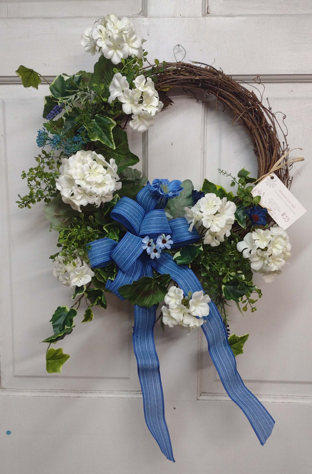 K469 - Wreath with White Geraniums with Blue Bow