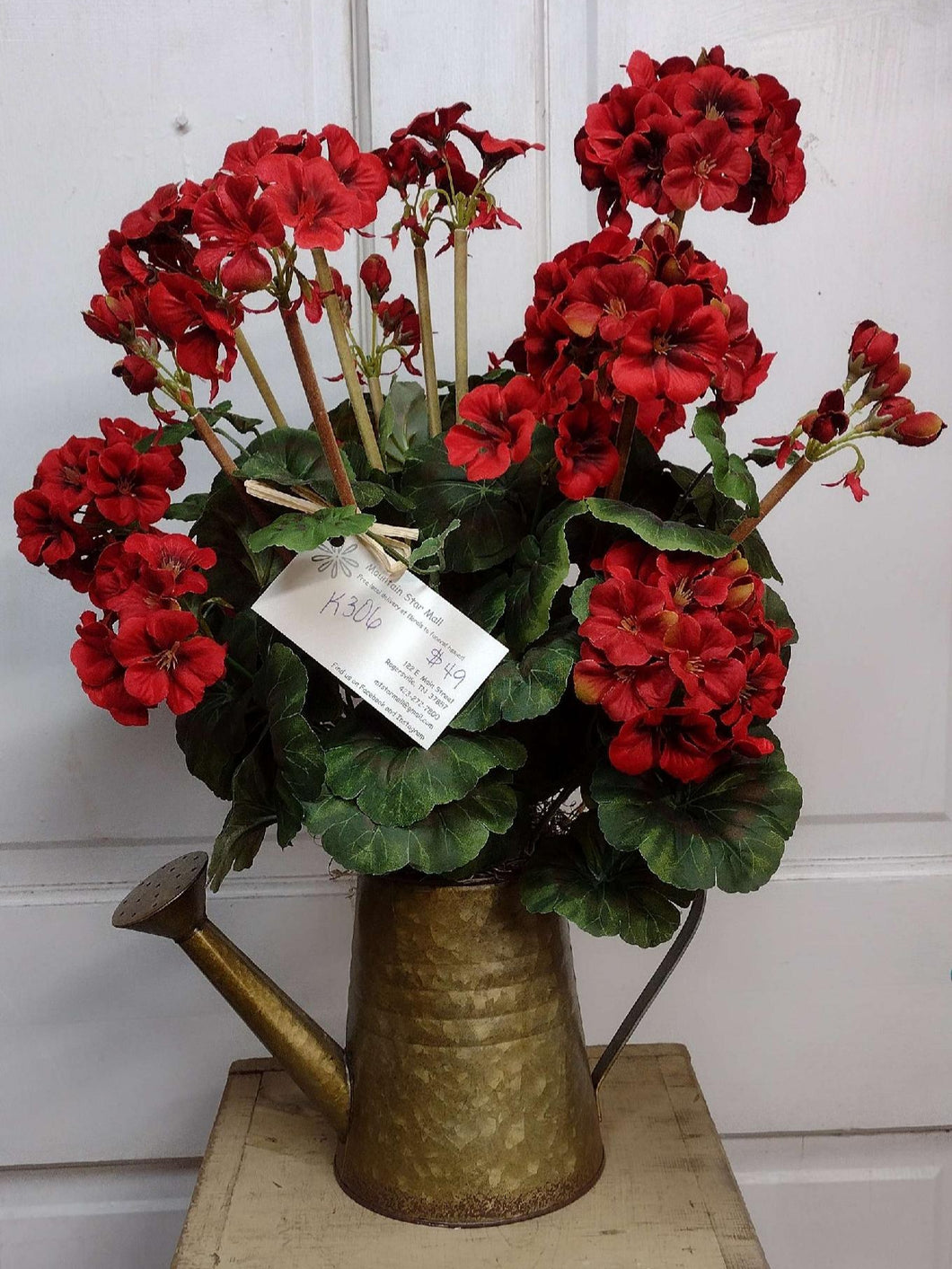 K306 - Arrangement with Red Geraniums in a Water Can